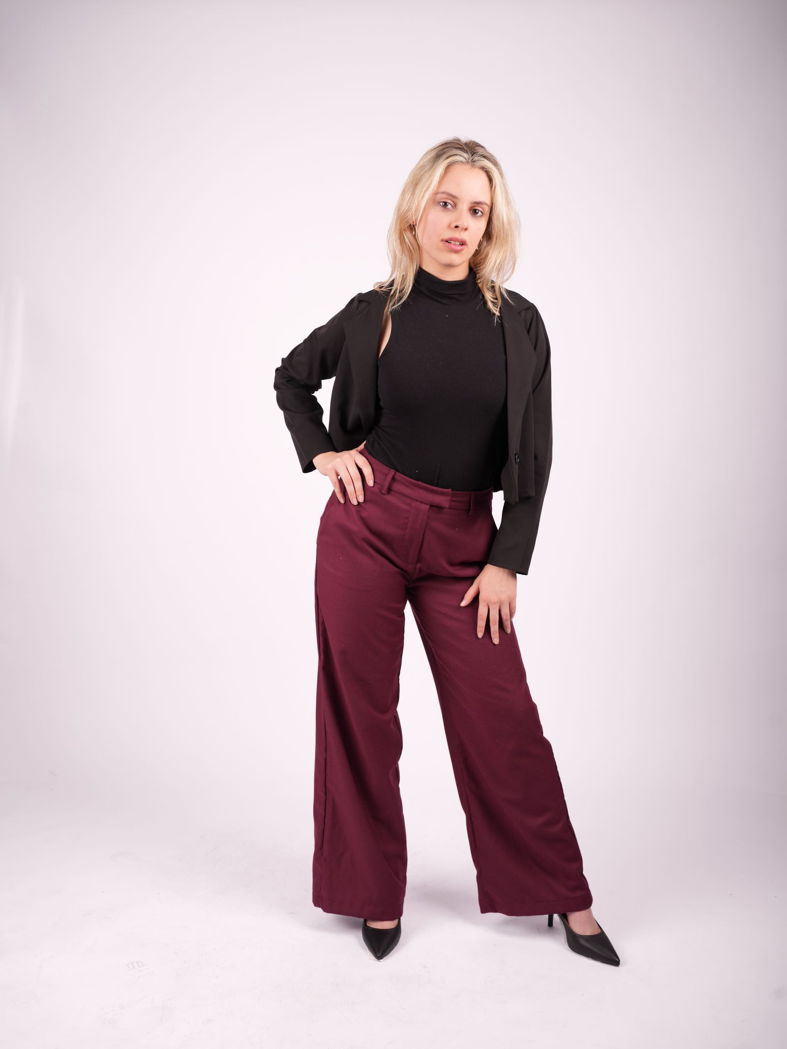 Martina de cuerpo entero con top negro y pantalón bordó.