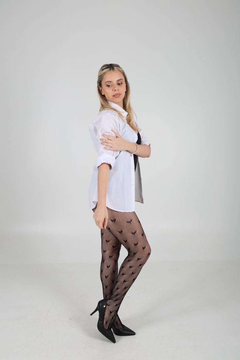 Martina de cuerpo entero con camisa blanca y medias estampadas.