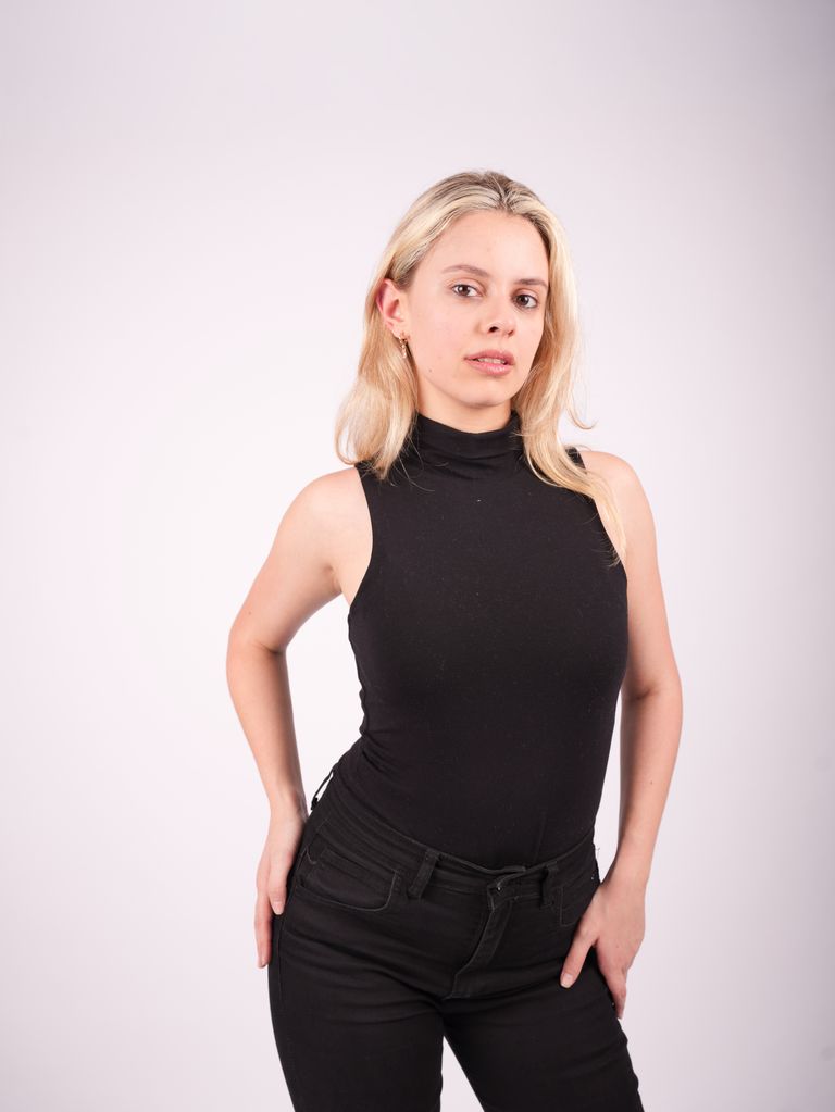 Martina con top negro sin mangas en un retrato de medio cuerpo.