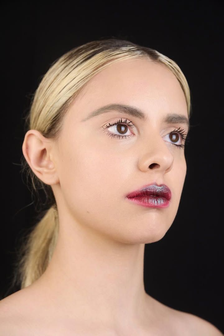 Retrato de beauty de Martina con labios rojos sobre fondo negro.