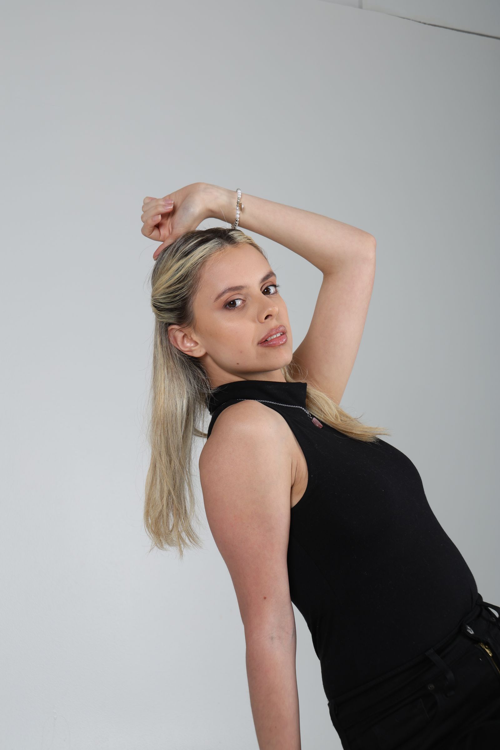 Martina vestida de negro en una pose diagonal con un brazo elevado.