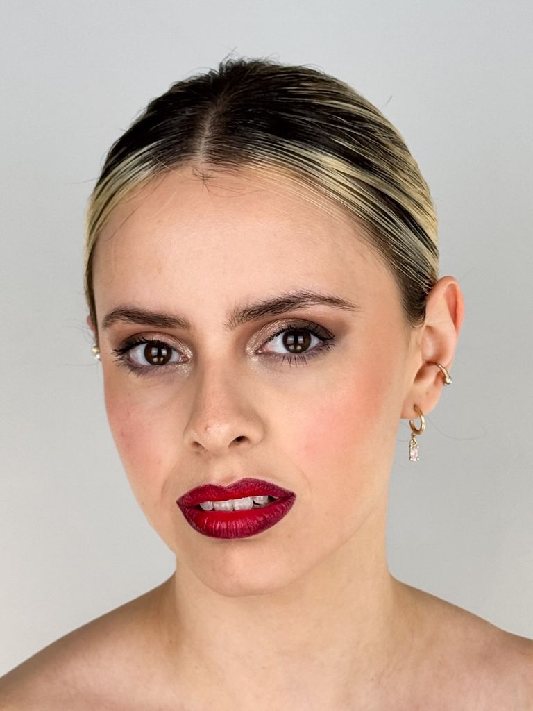 Primer plano de Martina con labios rojos sobre fondo claro.