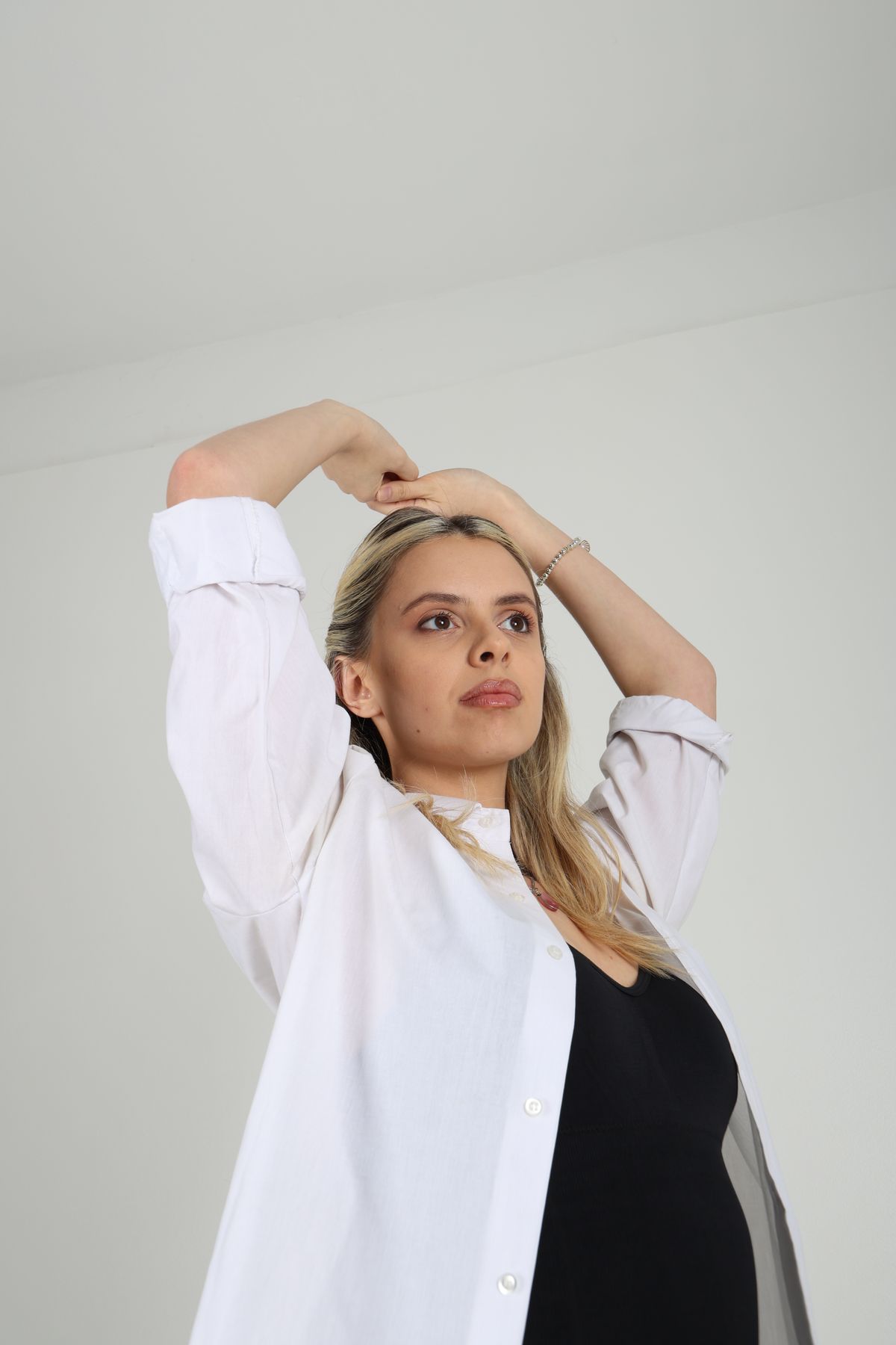 Retrato de Martina con camisa blanca y los brazos enmarcando el rostro.