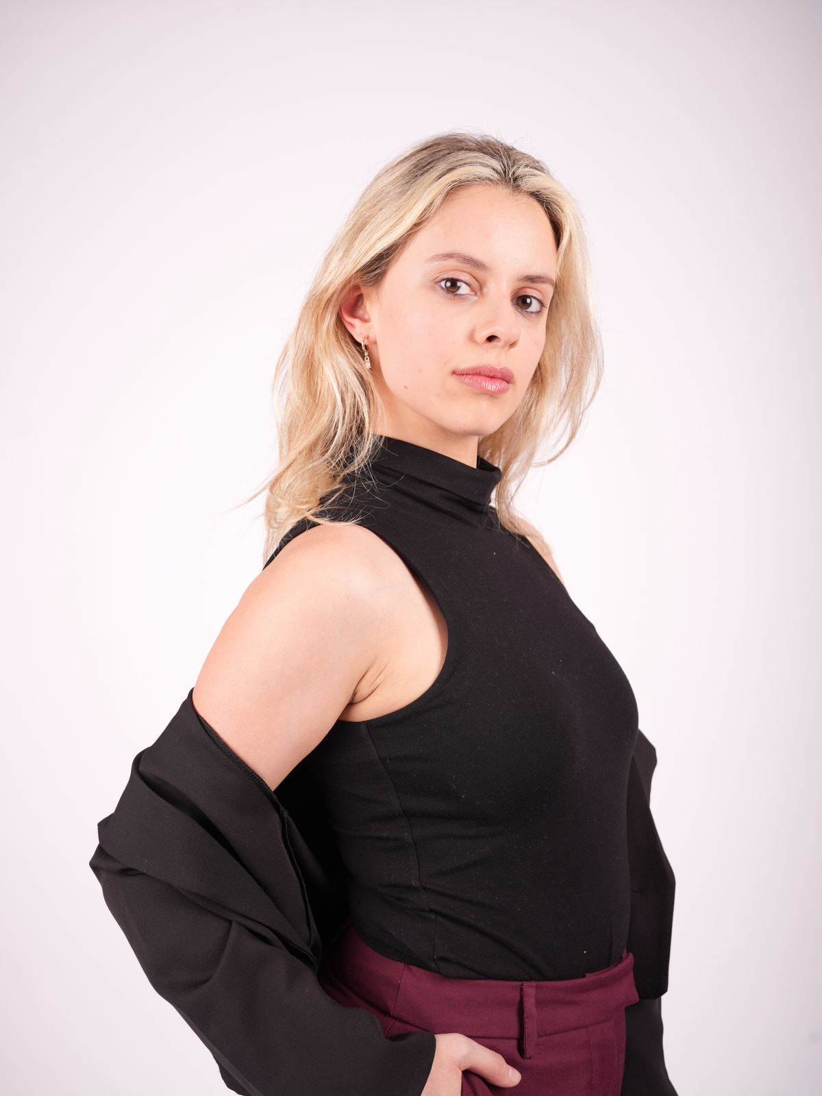 Retrato de Martina con top negro y chaqueta caída sobre los hombros.