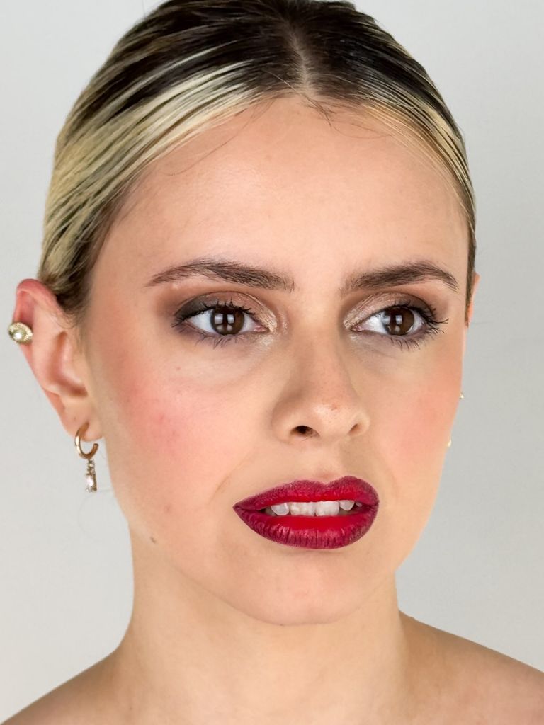 Primer plano de Martina con labios rojos y mirada lateral.