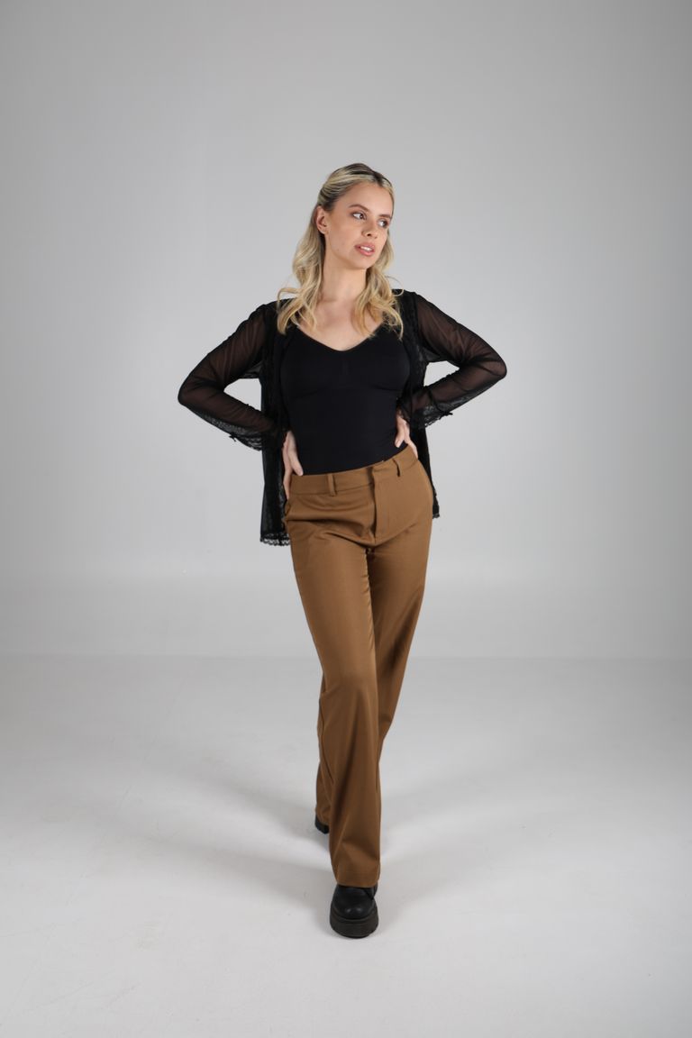 Martina de cuerpo entero con blusa negra y las manos en la cintura.