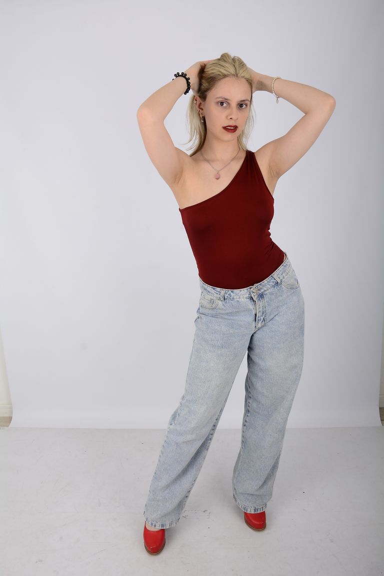 Martina de cuerpo entero con top rojo, jean y zapatos rojos.