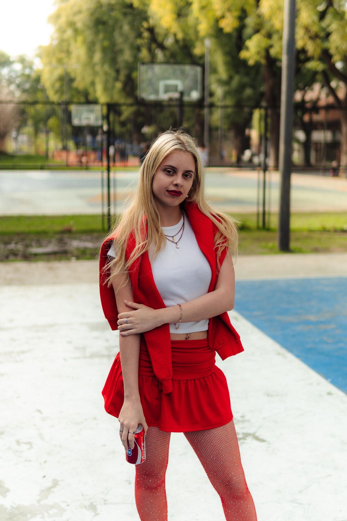 Martina de cuerpo entero con conjunto rojo en una cancha.